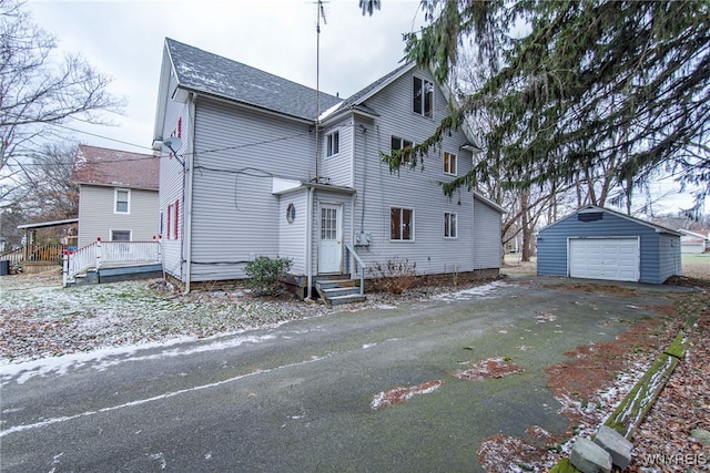 view of front facade featuring a garage and an outbuilding