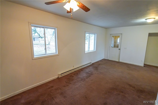 carpeted spare room with plenty of natural light, a baseboard heating unit, and ceiling fan