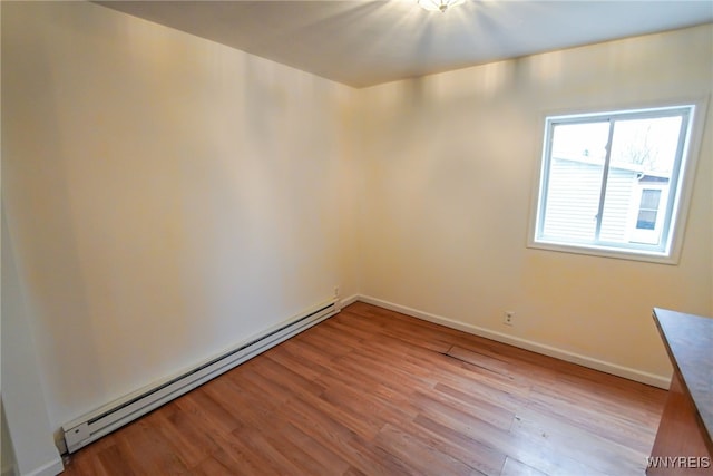 empty room with light wood-type flooring and baseboard heating