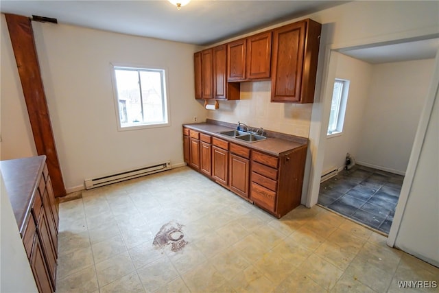 kitchen with decorative backsplash, a baseboard radiator, and sink