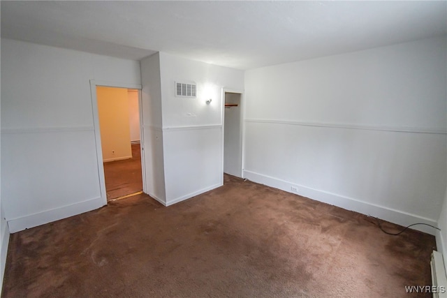 spare room with dark carpet