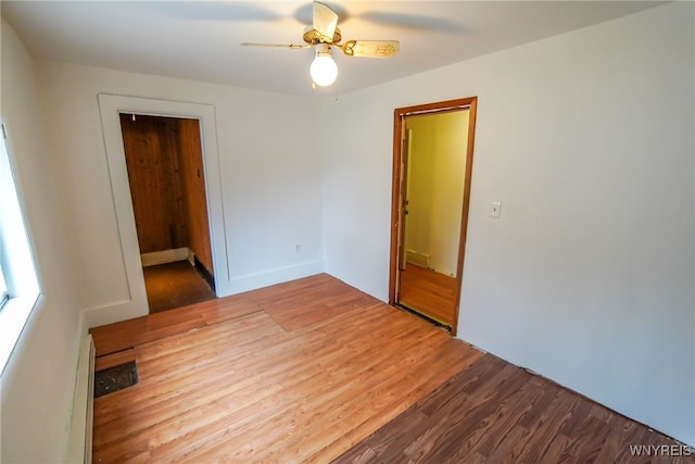 empty room with ceiling fan, wood-type flooring, and a baseboard radiator