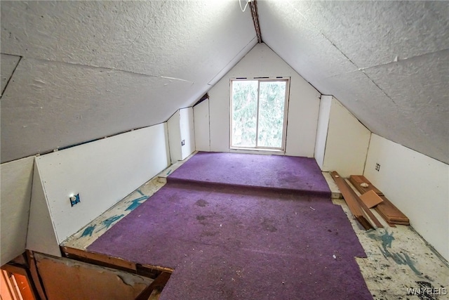 bonus room with a textured ceiling, carpet floors, and vaulted ceiling