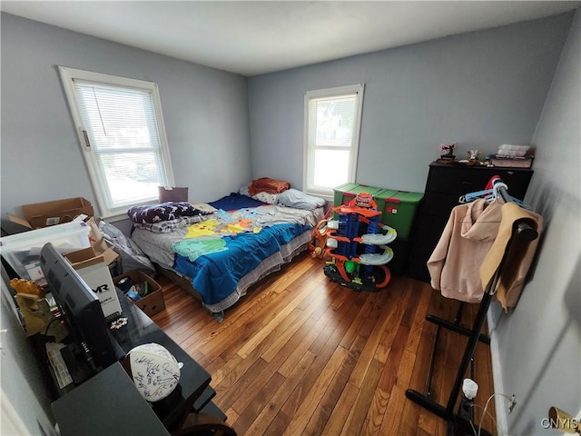 bedroom featuring wood-type flooring and multiple windows