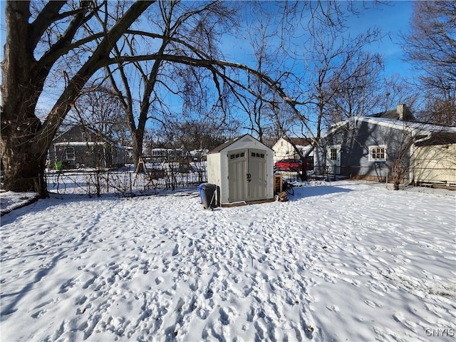 snowy yard with a storage shed