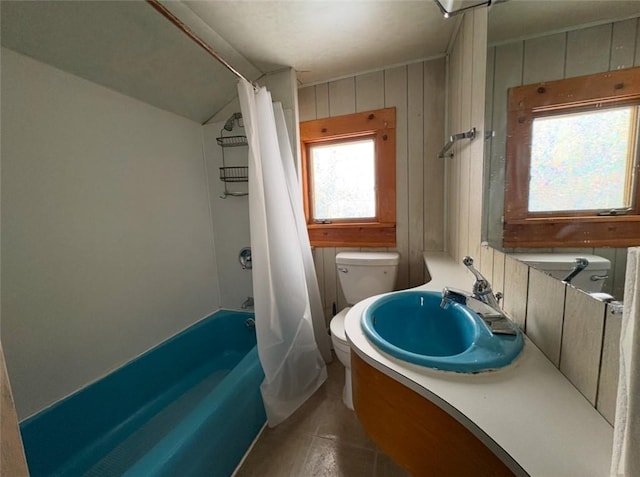 full bathroom with vanity, wooden walls, shower / bathtub combination with curtain, tile patterned flooring, and toilet