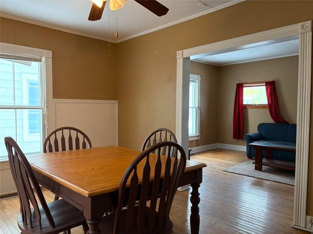 dining room with ceiling fan, ornamental molding, and light hardwood / wood-style flooring