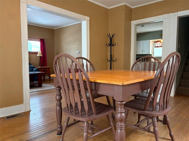 dining area featuring hardwood / wood-style floors and crown molding