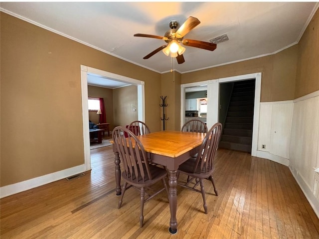 dining room with light hardwood / wood-style floors, ceiling fan, and crown molding