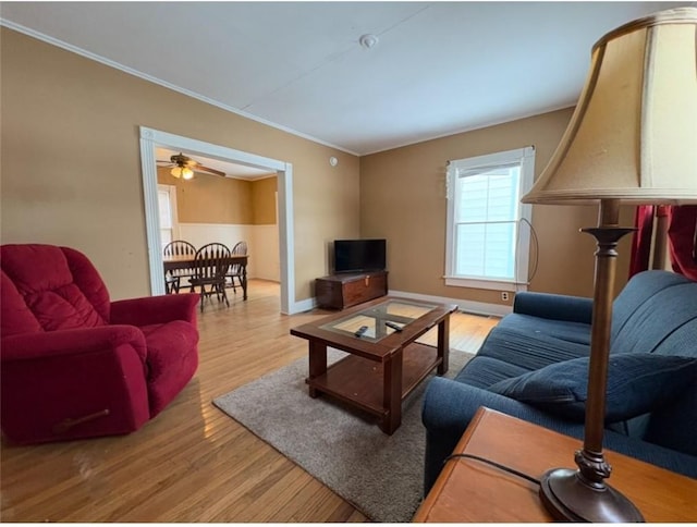 living room with wood-type flooring, ceiling fan, and crown molding