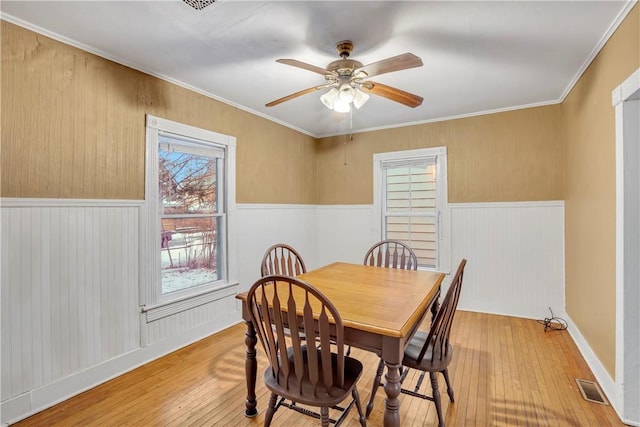 dining area with crown molding, light hardwood / wood-style flooring, and ceiling fan