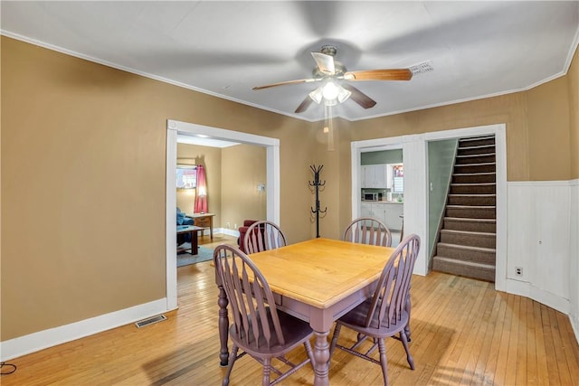 dining area with crown molding, ceiling fan, and light hardwood / wood-style floors