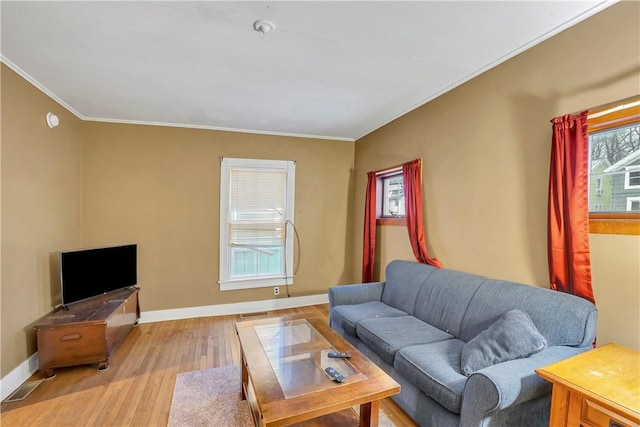 living room featuring crown molding and light hardwood / wood-style flooring