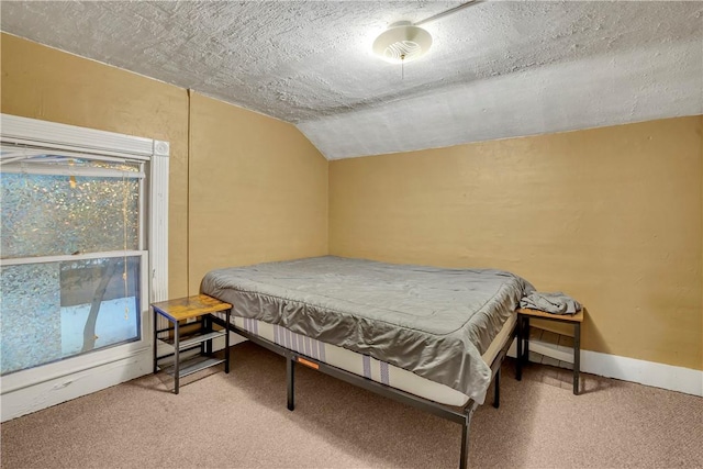 carpeted bedroom featuring vaulted ceiling and a textured ceiling