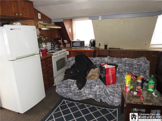 kitchen with wooden walls, extractor fan, and white appliances