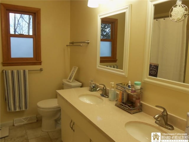 bathroom featuring tile patterned flooring, vanity, toilet, and radiator