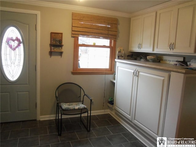 clothes washing area with cabinets, plenty of natural light, and crown molding