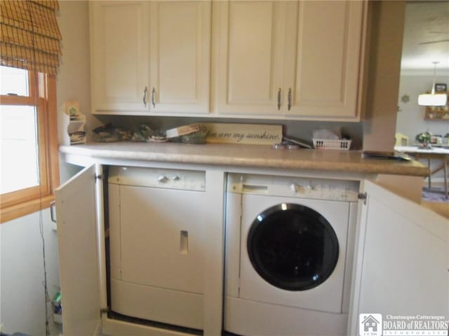 laundry area with washer and clothes dryer and cabinets