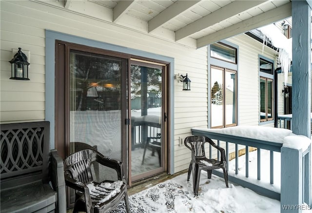 snow covered property entrance featuring a porch