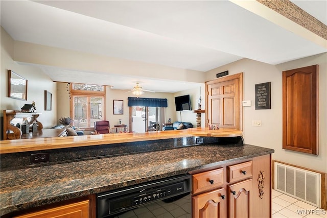 kitchen with dishwasher, ceiling fan, light tile patterned flooring, and dark stone counters