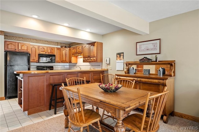 dining room with beamed ceiling, light tile patterned floors, and sink