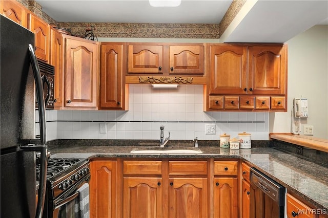 kitchen featuring tasteful backsplash, sink, dark stone counters, and black appliances