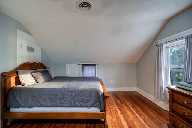 bedroom featuring hardwood / wood-style floors and vaulted ceiling