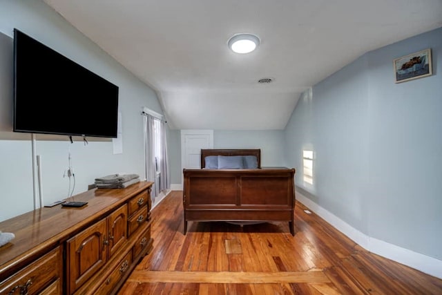 bedroom with lofted ceiling and hardwood / wood-style flooring