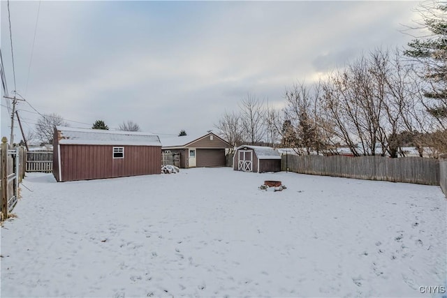 snow covered back of property featuring a storage shed