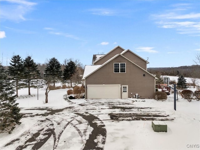 view of snowy exterior with a garage