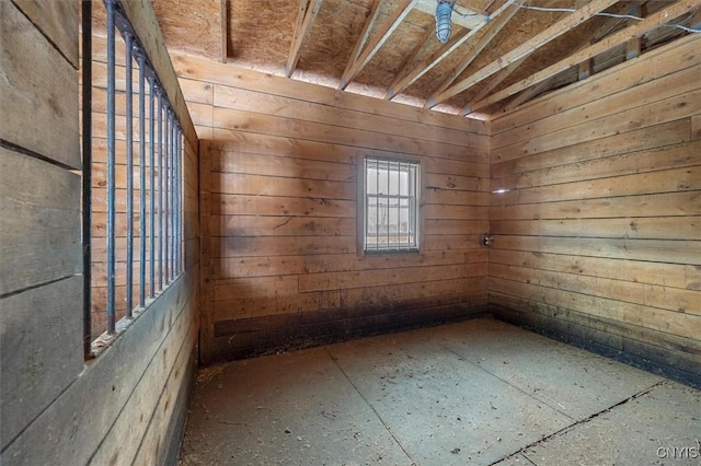 unfurnished room featuring wood walls