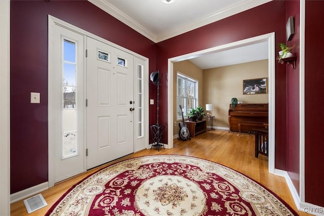 entryway featuring crown molding and light hardwood / wood-style flooring