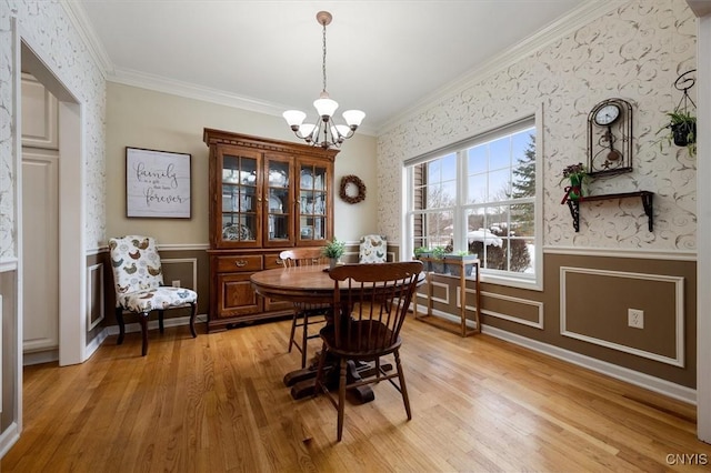 dining space with light wood-type flooring, an inviting chandelier, and crown molding