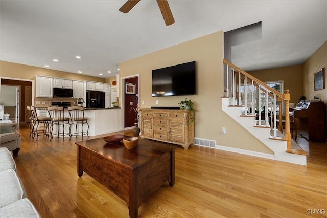 living room with ceiling fan and light wood-type flooring