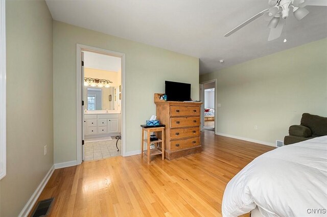 bedroom with ceiling fan, light wood-type flooring, and connected bathroom