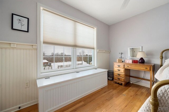 bedroom with ceiling fan, light hardwood / wood-style flooring, and radiator heating unit