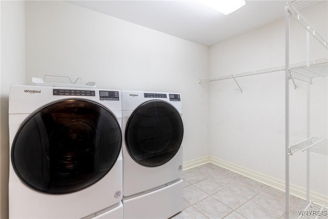 clothes washing area featuring light tile patterned flooring and washing machine and clothes dryer