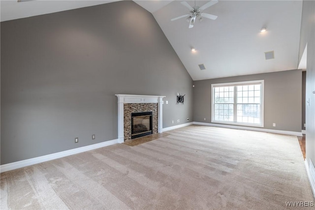 unfurnished living room with ceiling fan, a fireplace, high vaulted ceiling, and light colored carpet