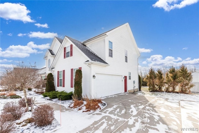 snow covered property featuring a garage