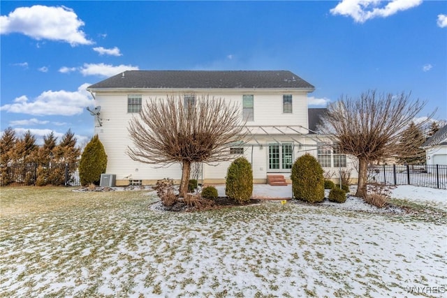 snow covered house featuring central AC unit