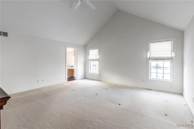 carpeted empty room with high vaulted ceiling and ceiling fan