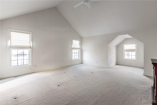 bonus room featuring ceiling fan, light colored carpet, and a healthy amount of sunlight