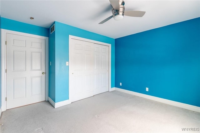 unfurnished bedroom with ceiling fan, light colored carpet, and a closet