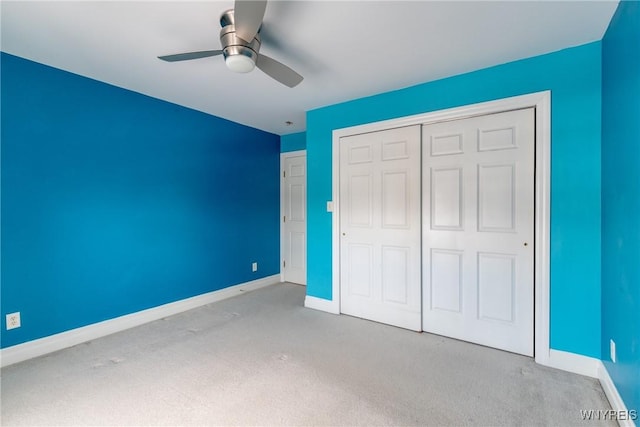 unfurnished bedroom with ceiling fan, a closet, and light carpet