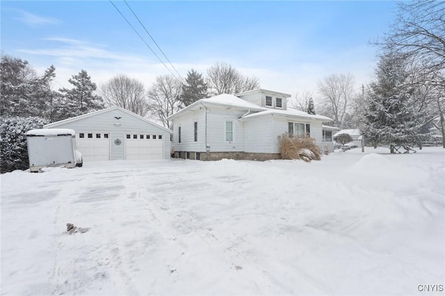 view of front of home with a garage and an outbuilding