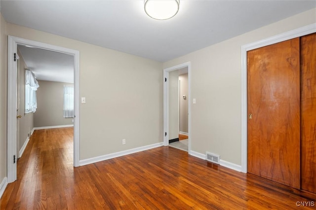 unfurnished bedroom featuring wood-type flooring and a closet