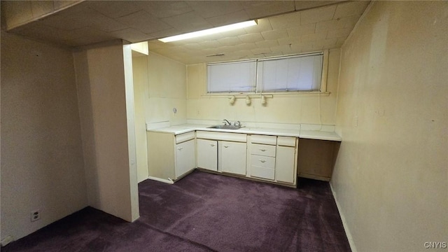 kitchen with white cabinetry, dark carpet, and sink