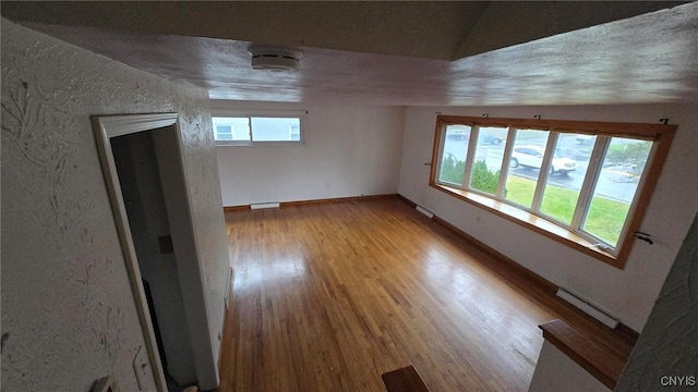 unfurnished room with hardwood / wood-style floors and vaulted ceiling