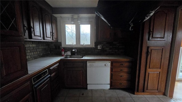 kitchen featuring tile counters, dishwasher, sink, backsplash, and light tile patterned flooring