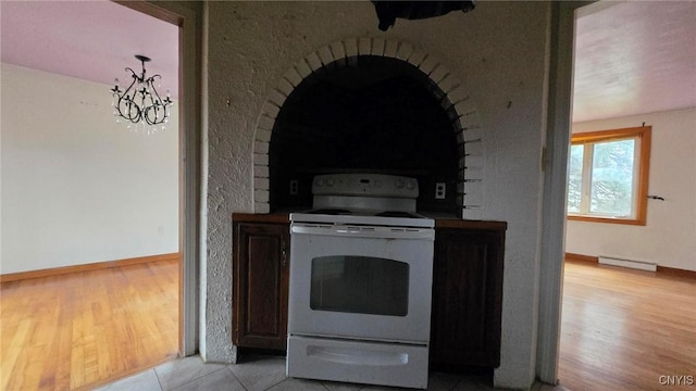 kitchen featuring light tile patterned flooring, electric stove, and a baseboard heating unit